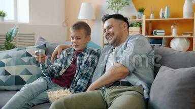 小男孩在家看电视，有<strong>爱心</strong>的爸爸坐在客厅的沙发上<strong>聊天</strong>